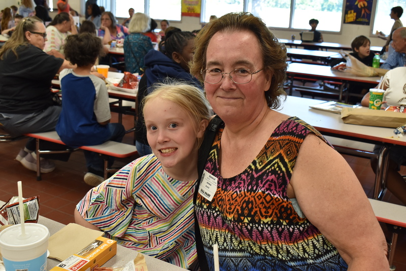 Grandparents and families at lunch with students.