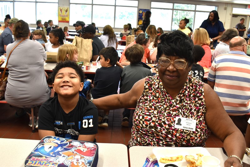 Grandparents and families at lunch with students.