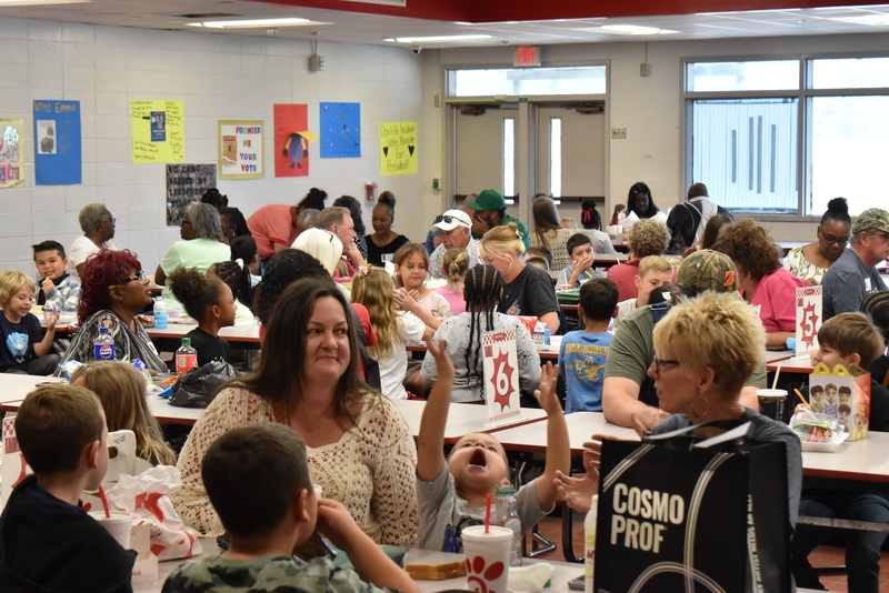 Grandparents and families at lunch with students.
