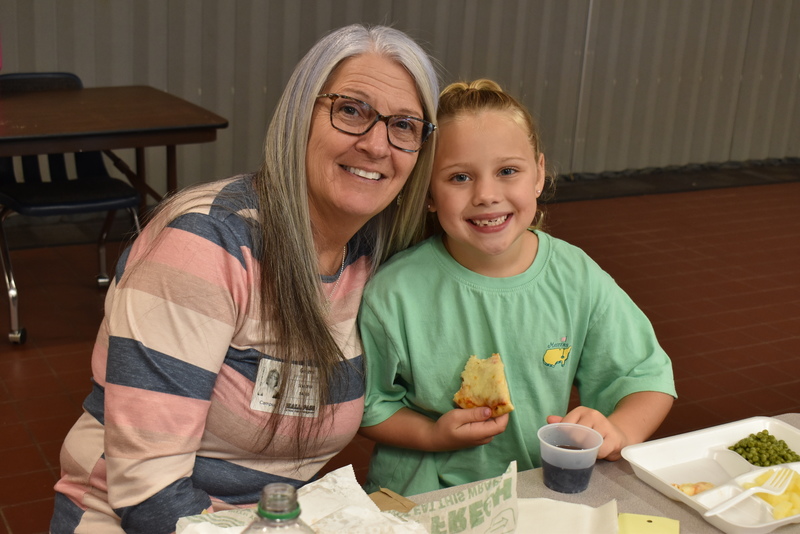 Grandparents and families at lunch with students.