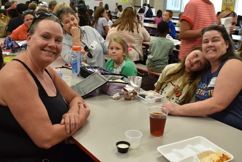 Grandparents and families at lunch with students.