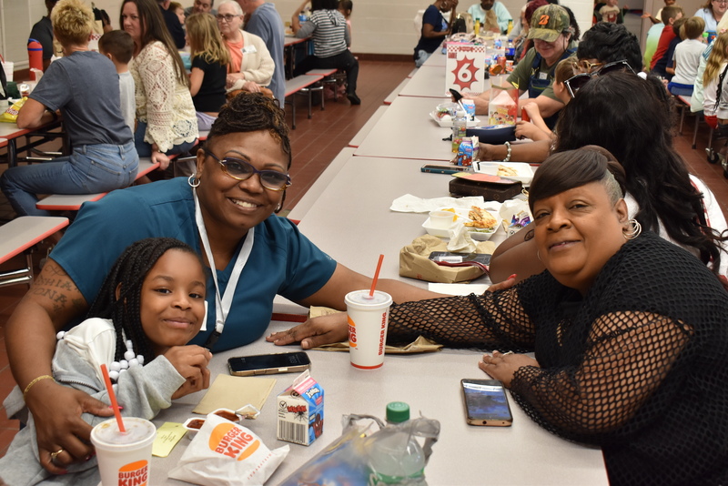 Grandparents and families at lunch with students.