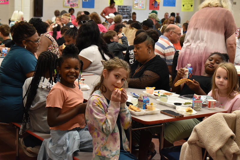 Grandparents and families at lunch with students.