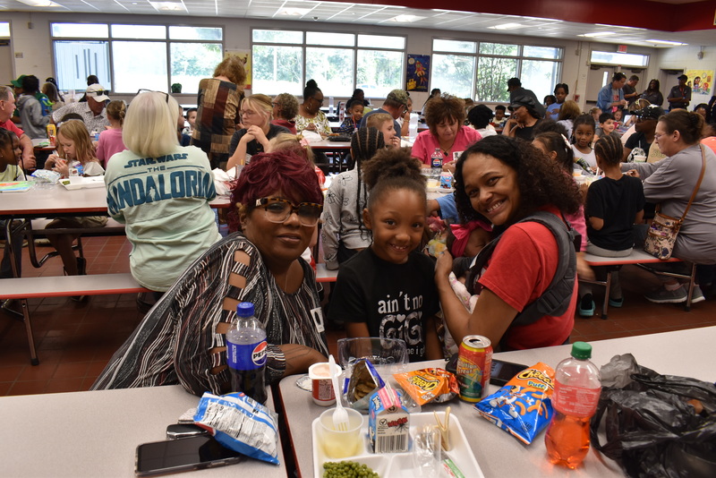 Grandparents and families at lunch with students.