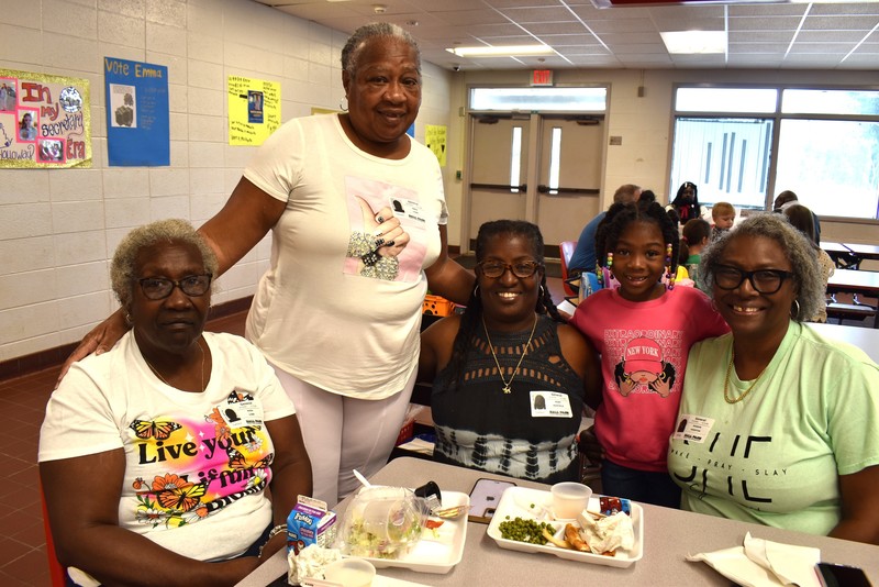 Grandparents and families at lunch with students.
