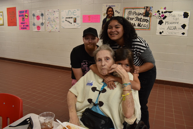 Grandparents and families at lunch with students.