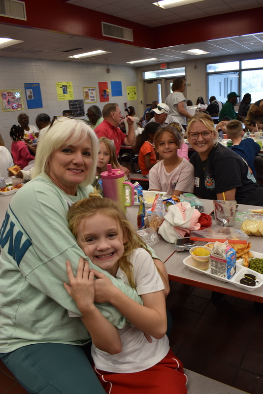 Grandparents and families at lunch with students.