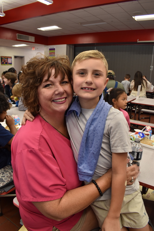 Grandparents and families at lunch with students.