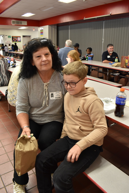 Grandparents and families at lunch with students.