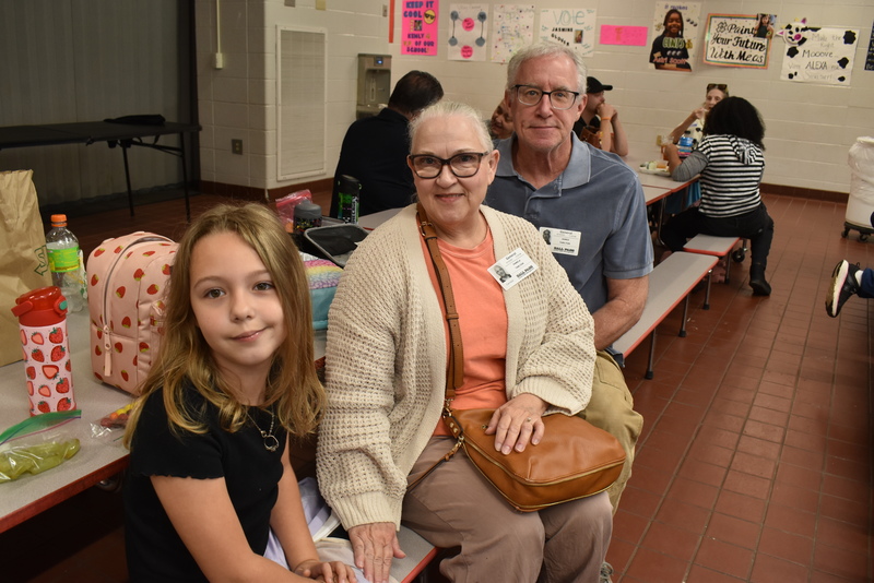 Grandparents and families at lunch with students.