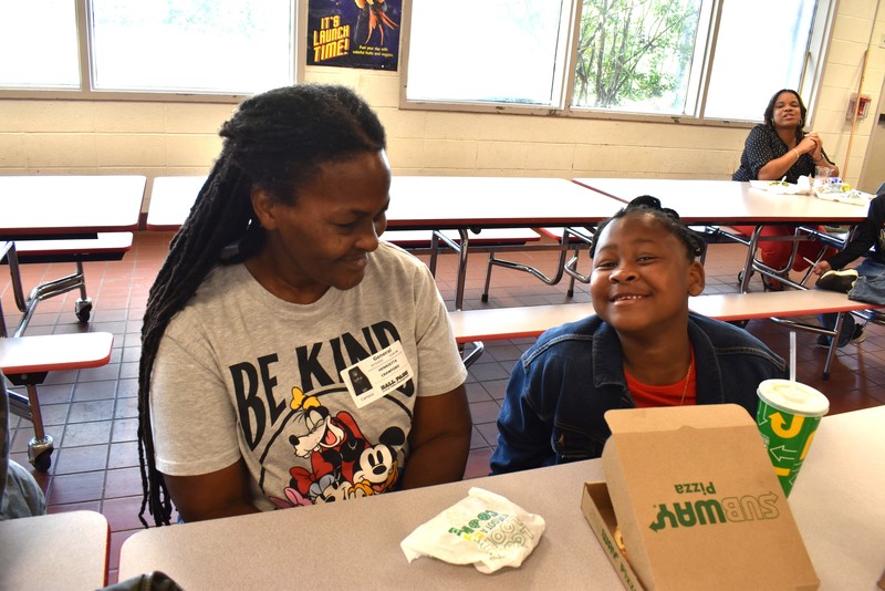 Grandparents and families at lunch with students.