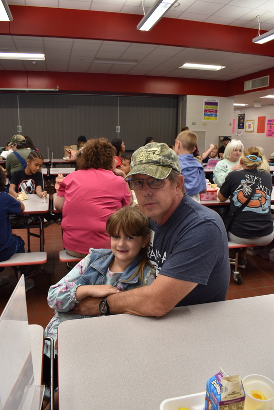 Grandparents and families at lunch with students.