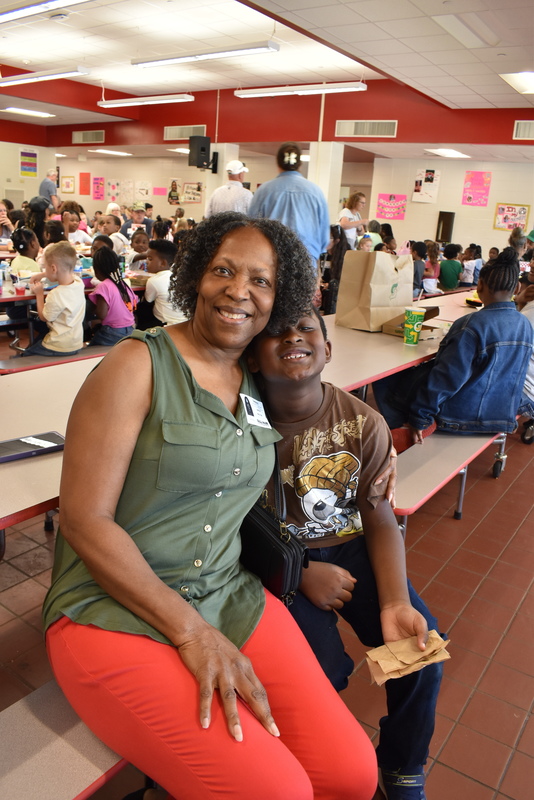 Grandparents and families at lunch with students.