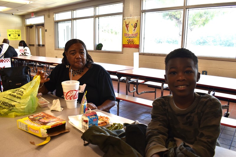 Grandparents and families at lunch with students.