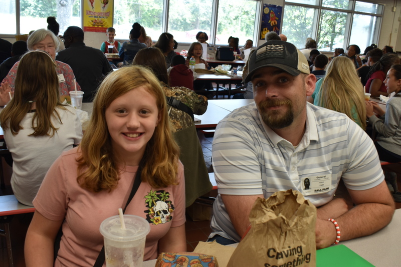 Grandparents and families at lunch with students.