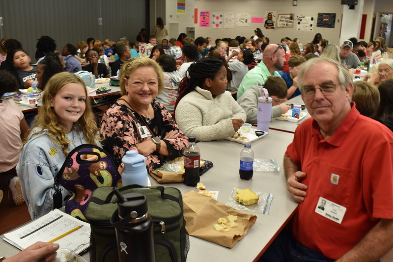 Grandparents and families at lunch with students.