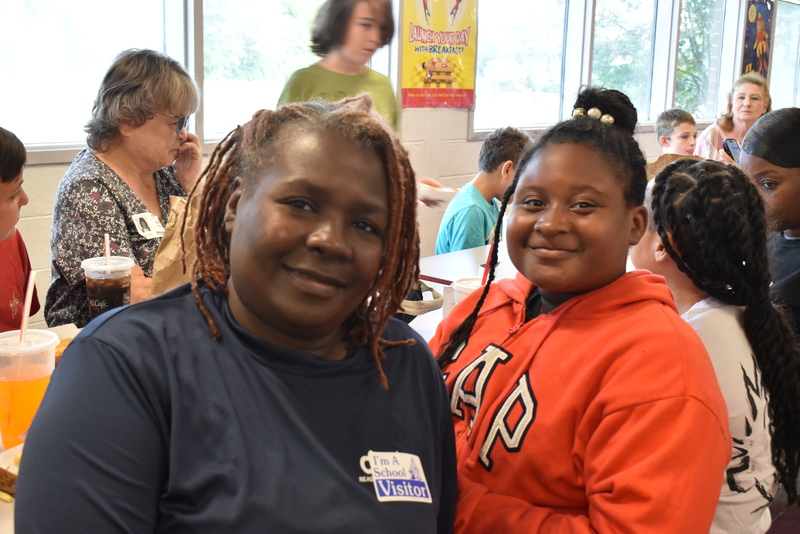Grandparents and families at lunch with students.
