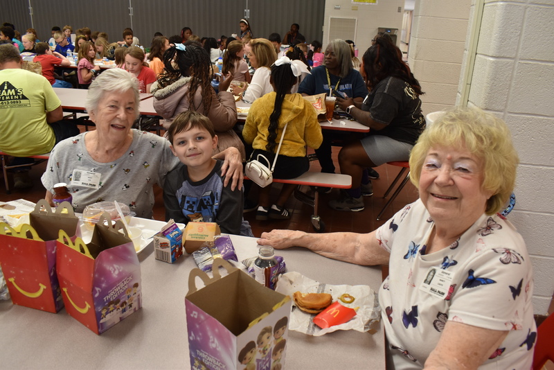 Grandparents and families at lunch with students.