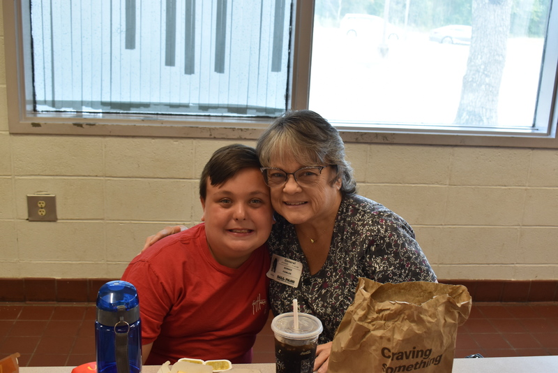 Grandparents and families at lunch with students.