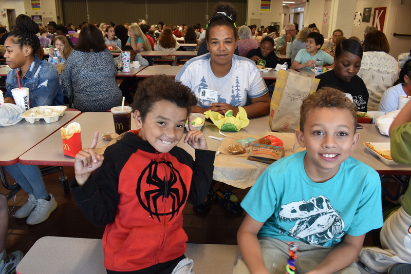 Grandparents and families at lunch with students.