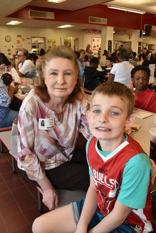 Grandparents and families at lunch with students.