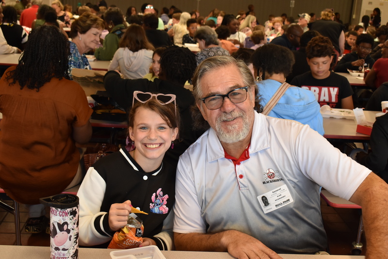 Grandparents and families at lunch with students.