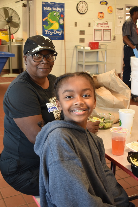 Grandparents and families at lunch with students.