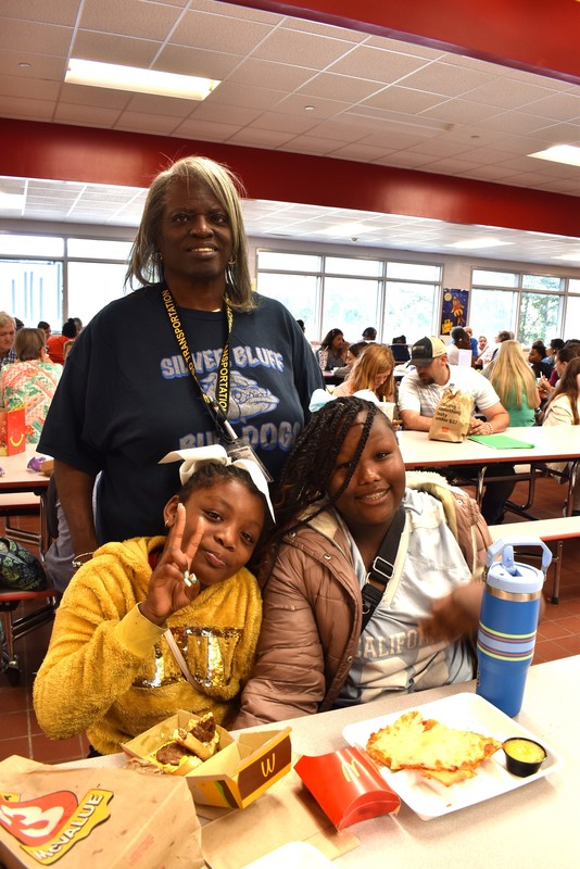 Grandparents and families at lunch with students.