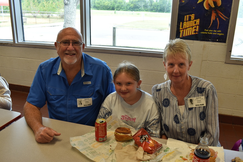 Grandparents and families at lunch with students.