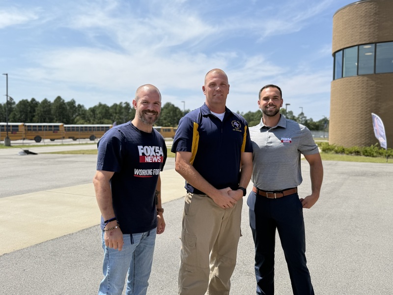 Midland Valley High NJROTC instructor standing outside the school with FOX54 reporter and crew member. 