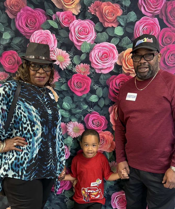 Grandparents Day celebration at elementary school, grandmother with grandchild holding sign. 