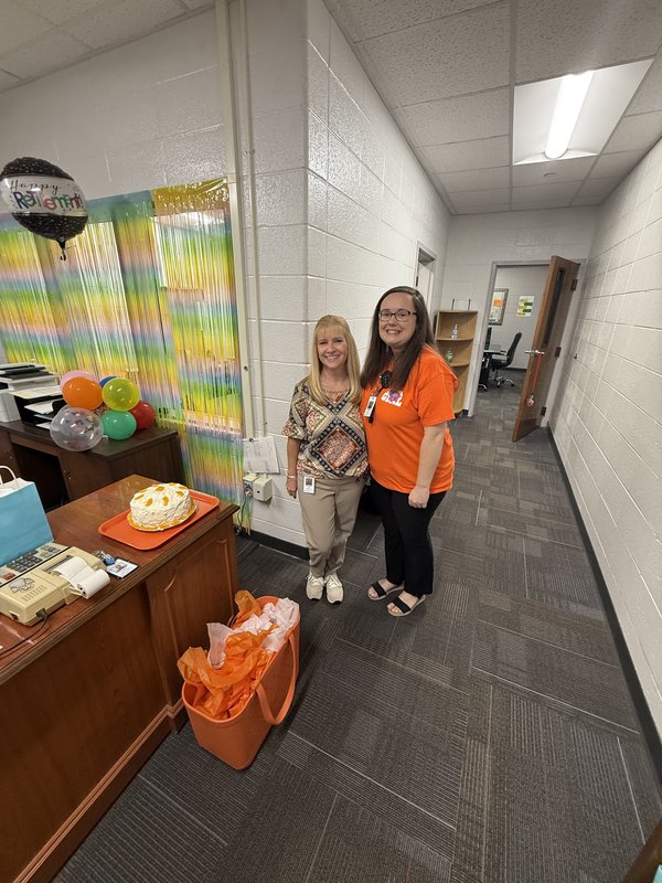 Two women standing in office.