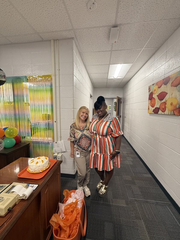 Two women standing in office.