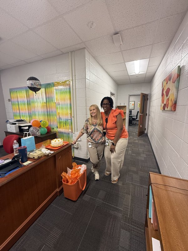 Two women standing in office.