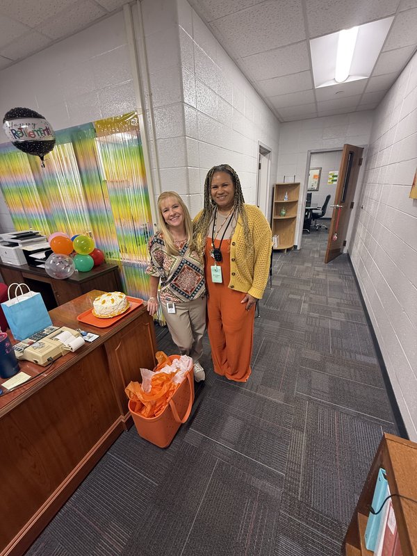 Two women standing in office.