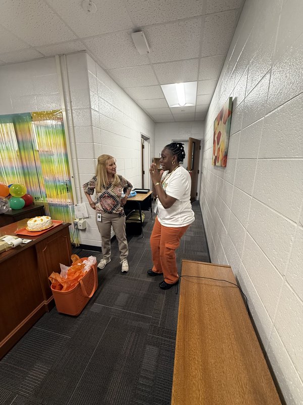Two women standing in office.