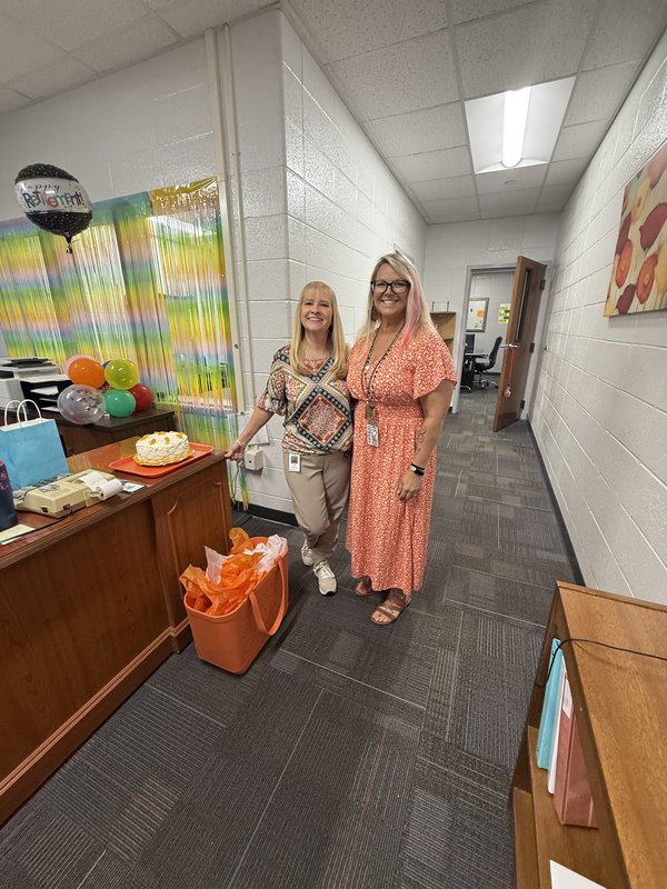 Two women standing in office.