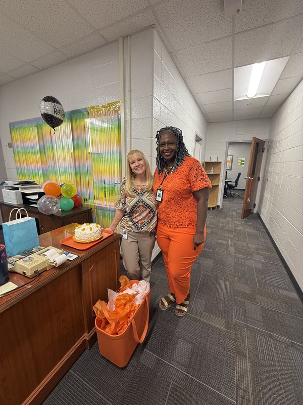 Two women standing in office.