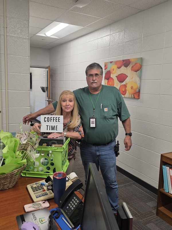 Woman and man holding Coffee Time sign.
