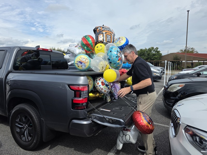 Man putting balloons in truck.