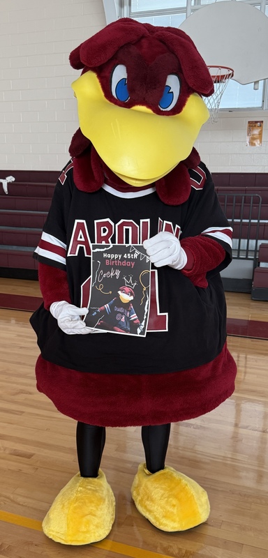The USC mascot, Cocky, holds a birthday card from 5th grade students.