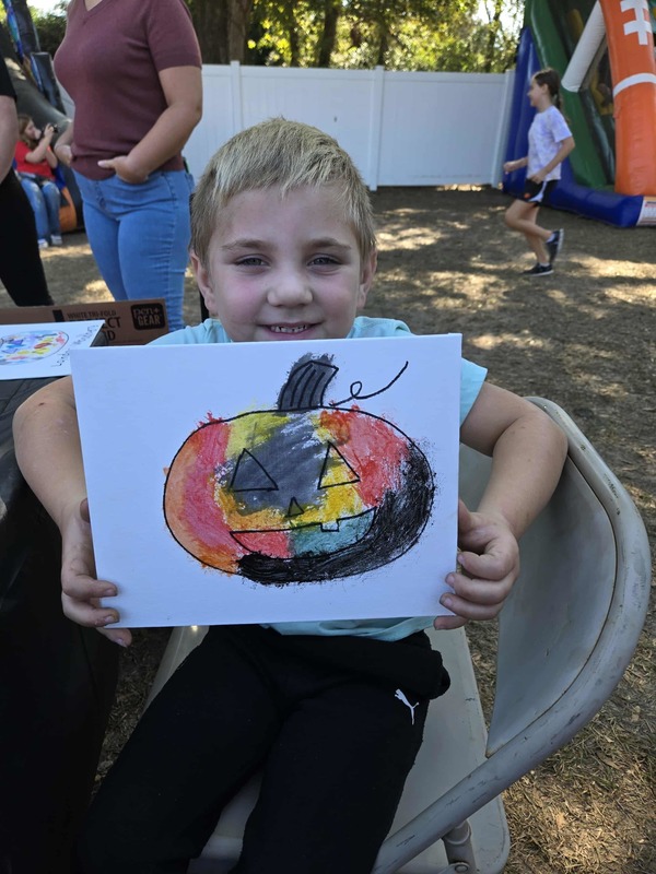 Student with painting at Hook n Cook festival.