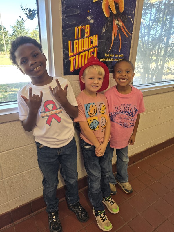 Three students wearing pink.