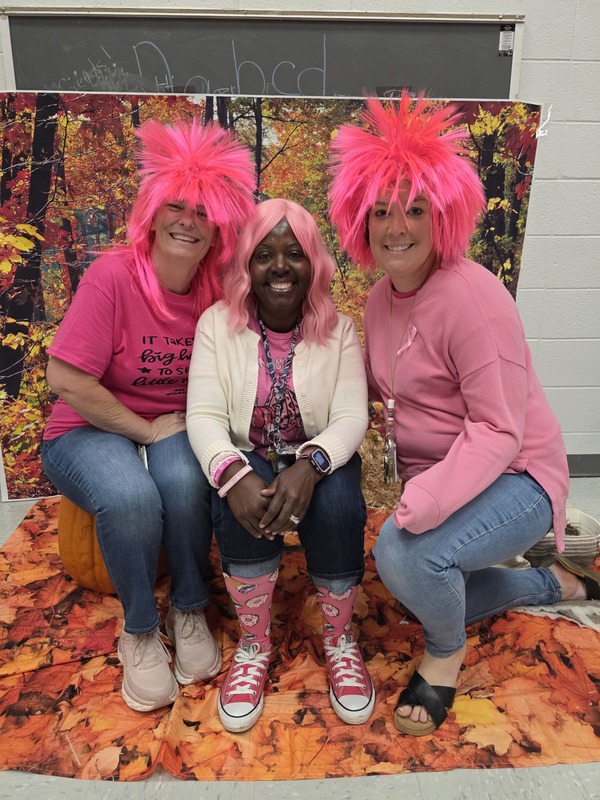 Three teachers wearing pink.