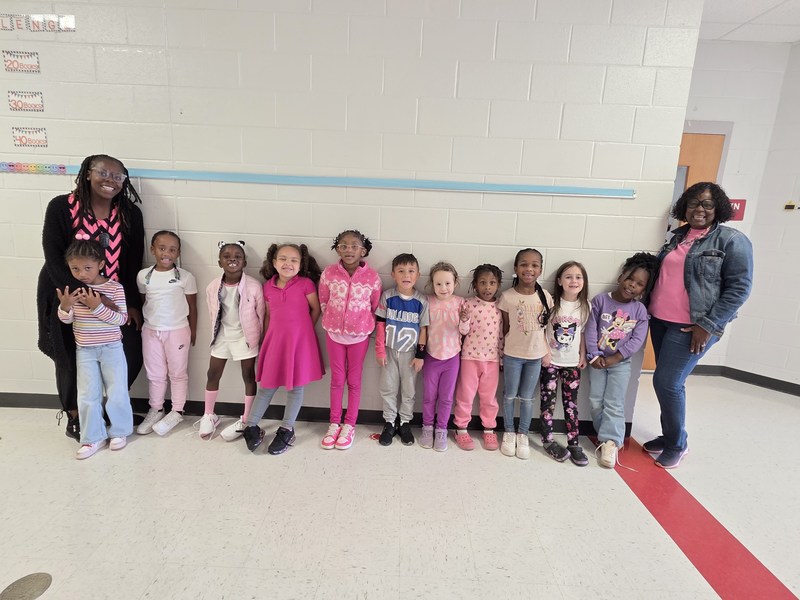 Group of students and staff wearing pink.