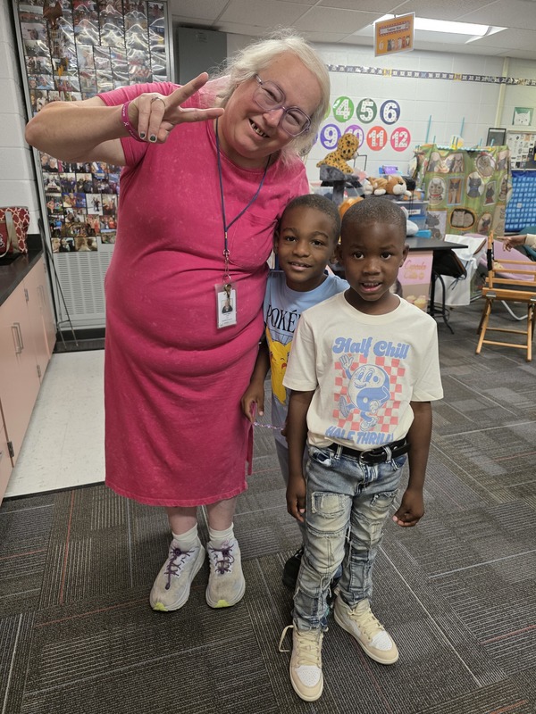 Teacher and two students wearing pink.