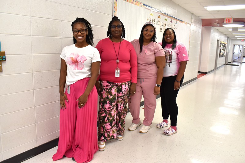 Four staff membrs wearing pink.