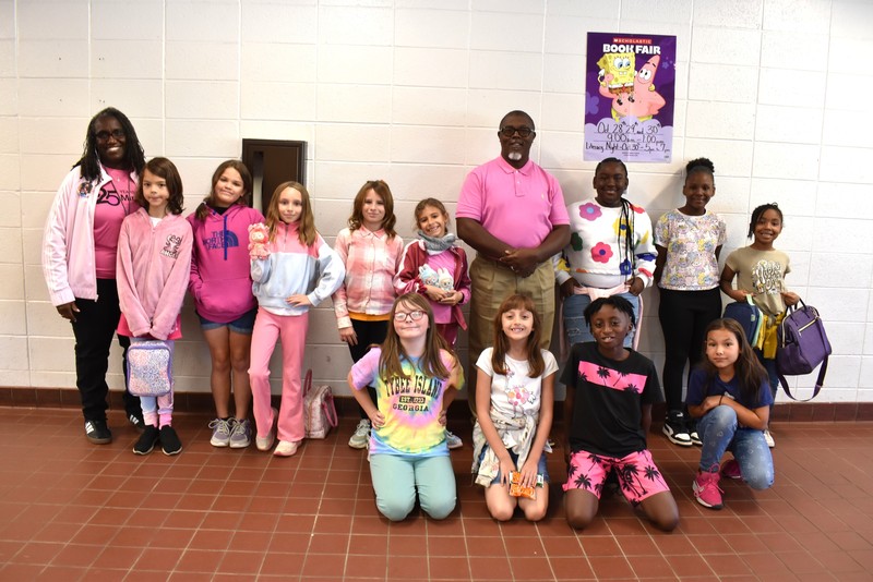 Group of students and staff wearing pink.