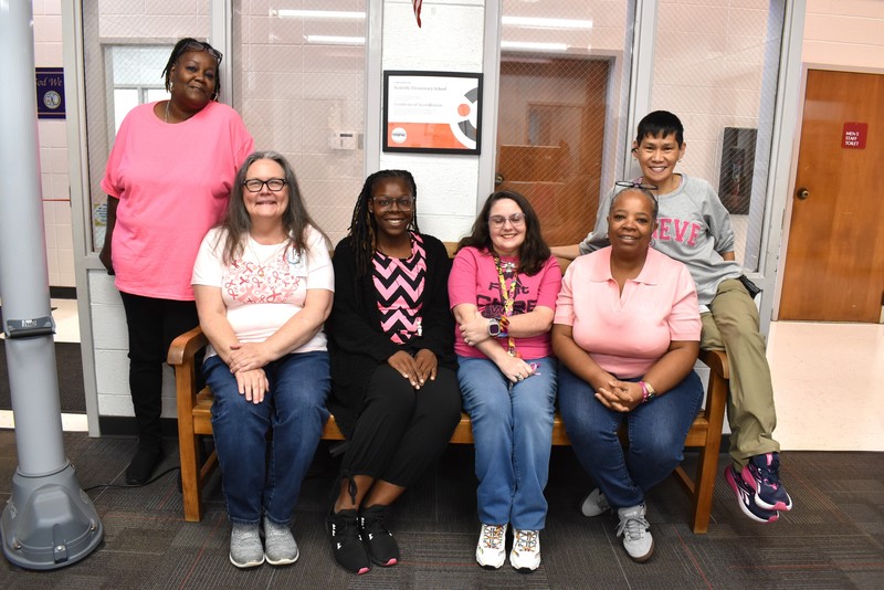 Six staff members wearing pink.