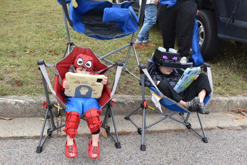 Two students sitting playing on tablets.